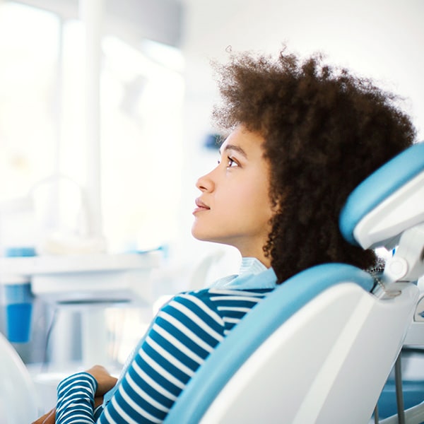 A woman in the dentist's chair listening