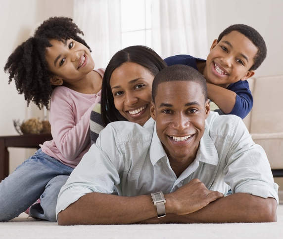 Young parents with two kids jumping on each other