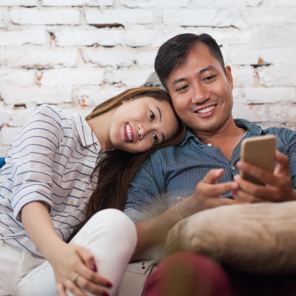 Smiling couple looking at a mobile phone
