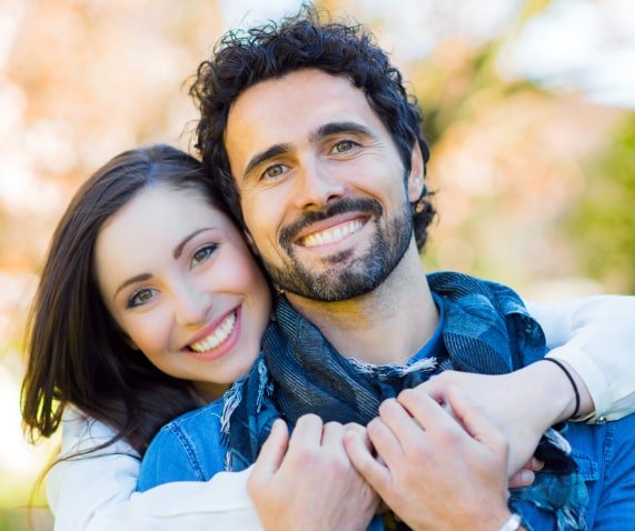 Happy couple hugging in a park