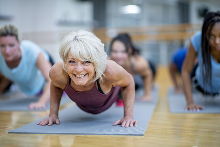 Older women doing push-ups on a mat in excercise class